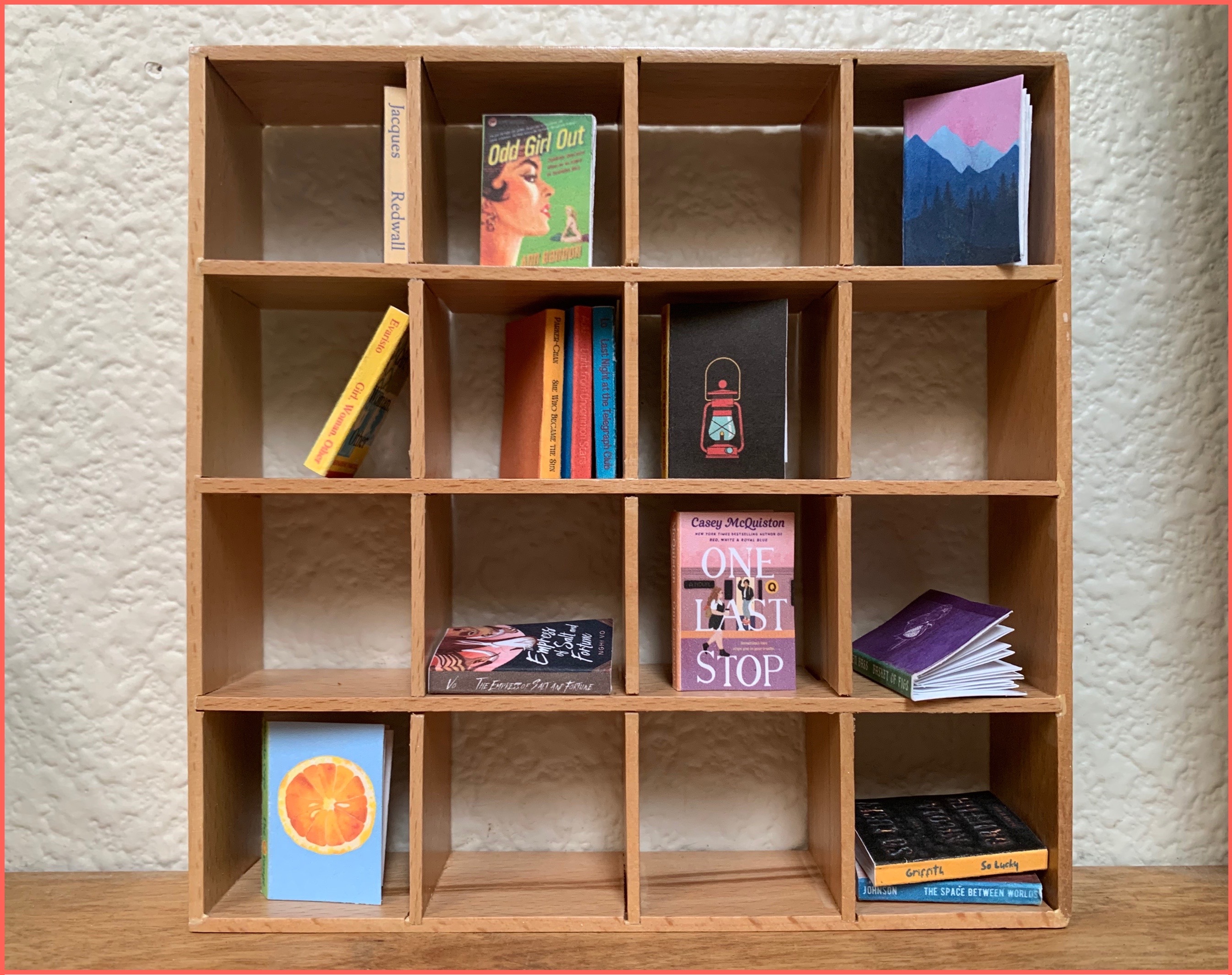 A 1:12 scale, Ikea-style bookshelf full of tiny books