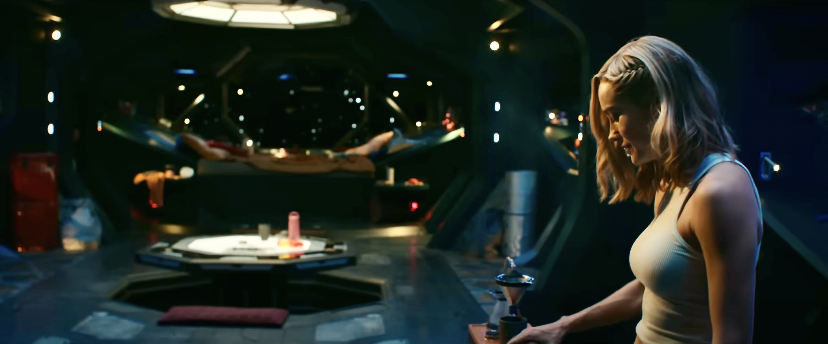 In the Marvels, Captain Marvel wears a white tank top and cooks on her space ship.