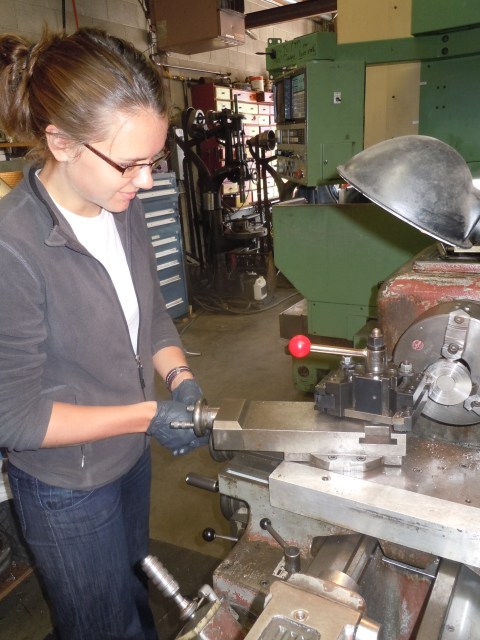 Me working a lathe (a fancy metal cutter) to construct a thermometer-housing case in a mechanics shop at the University of Washington, post-transition into the sciences.