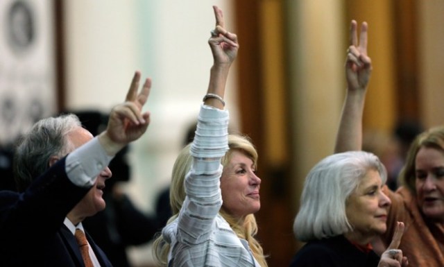 wendy-davis-holds-up-two-fingers-to-signal-a-no-vote-as-the-session-she-tried-to-filibuster-draws