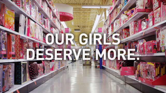 A pink toy aisle with the words "Our Girls Deserve More" over top.