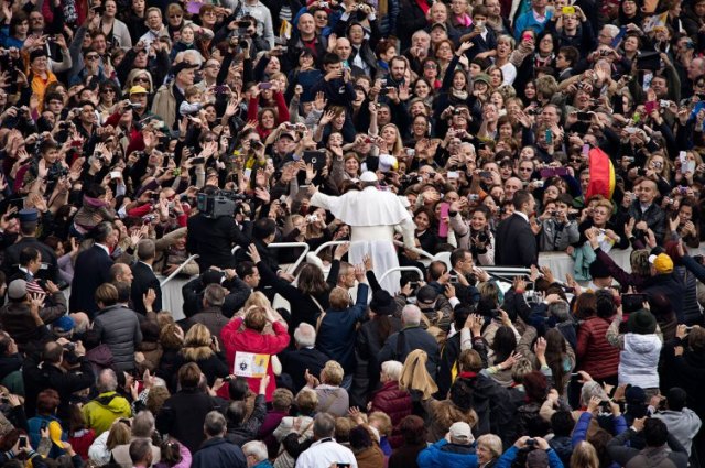 Pope stands in a crowd of people.