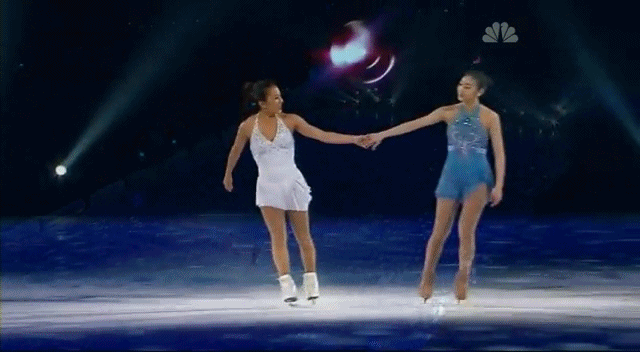 Michelle Kwan and Yuna Kim hold hands going into a T-stop.
