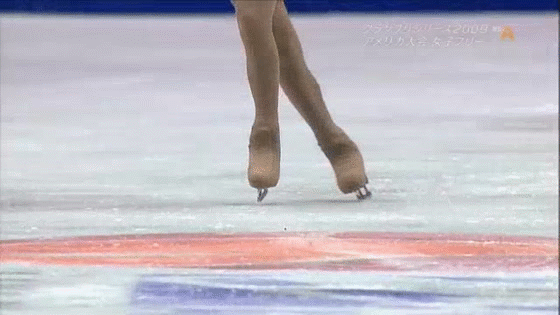 Closeup of Kim's skates during a triple lutz triple toe loop combination.