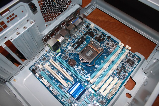 Line up the motherboard against the inside of the holes.