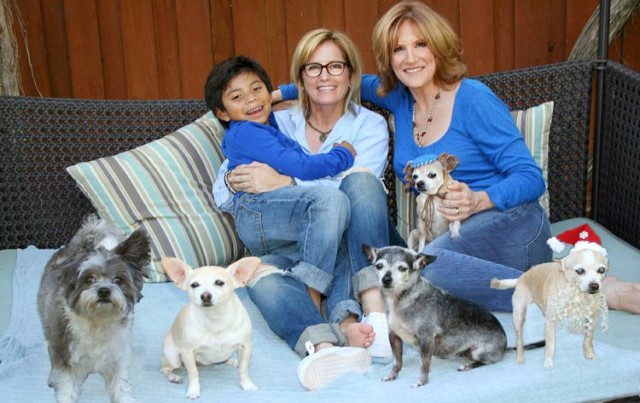 Leifer's son Bruno, her partner Lori Wolf and Carol Leifer herself with their eight rescue dogs, via life after 50