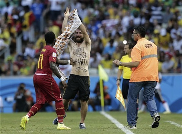 The neo-Nazi infiltrator takes off his shirt to reveal the message on his chest at the Ghana-Germany game via News Observer