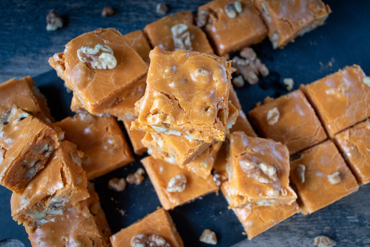 Pumpkin fudge squares with walnuts in cute Halloween setting with smiling pumpkins