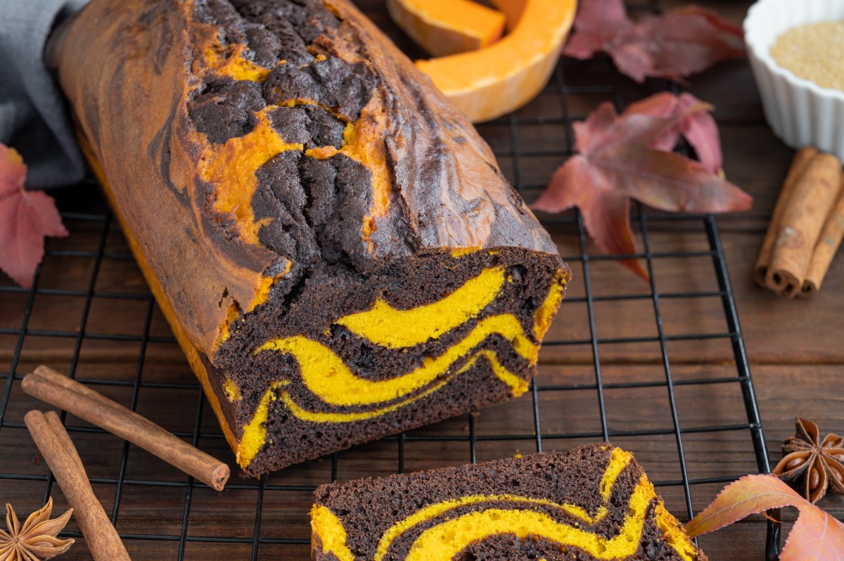 Pumpkin chocolate marble cake or bread on a dark wooden background. Dessert for Thanksgiving or Halloween
