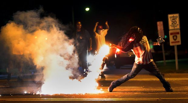 The now iconic photo of Edward Crawford throwing back a tear gas container after tactical officers worked to break up a group of bystanders. Photo by Robert Cohen, rcohen@post-dispatch.com. Via STLToday.