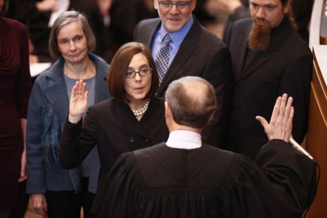 Chief Justice Thomas Balmer administers the oath of office to Secretary of State Kate Brown in the House chamber of the Oregon Capitol on Feb. 18, 2015. Brown becomes the state's 38th governor, succeeding John Kitzhaber, who resigned amid an ethics scandal. Bruce Ely/Staff