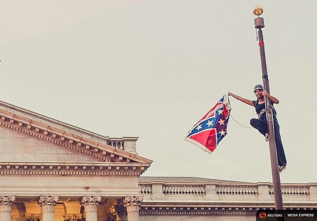 via Vox Bree Newsome triumphantly taking down the Confederate Flag