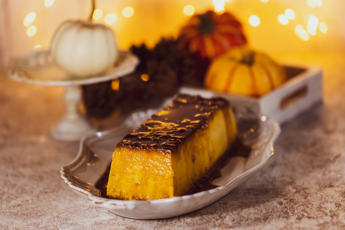 A stick of pumpkin creme brulee with pumpkins in the background