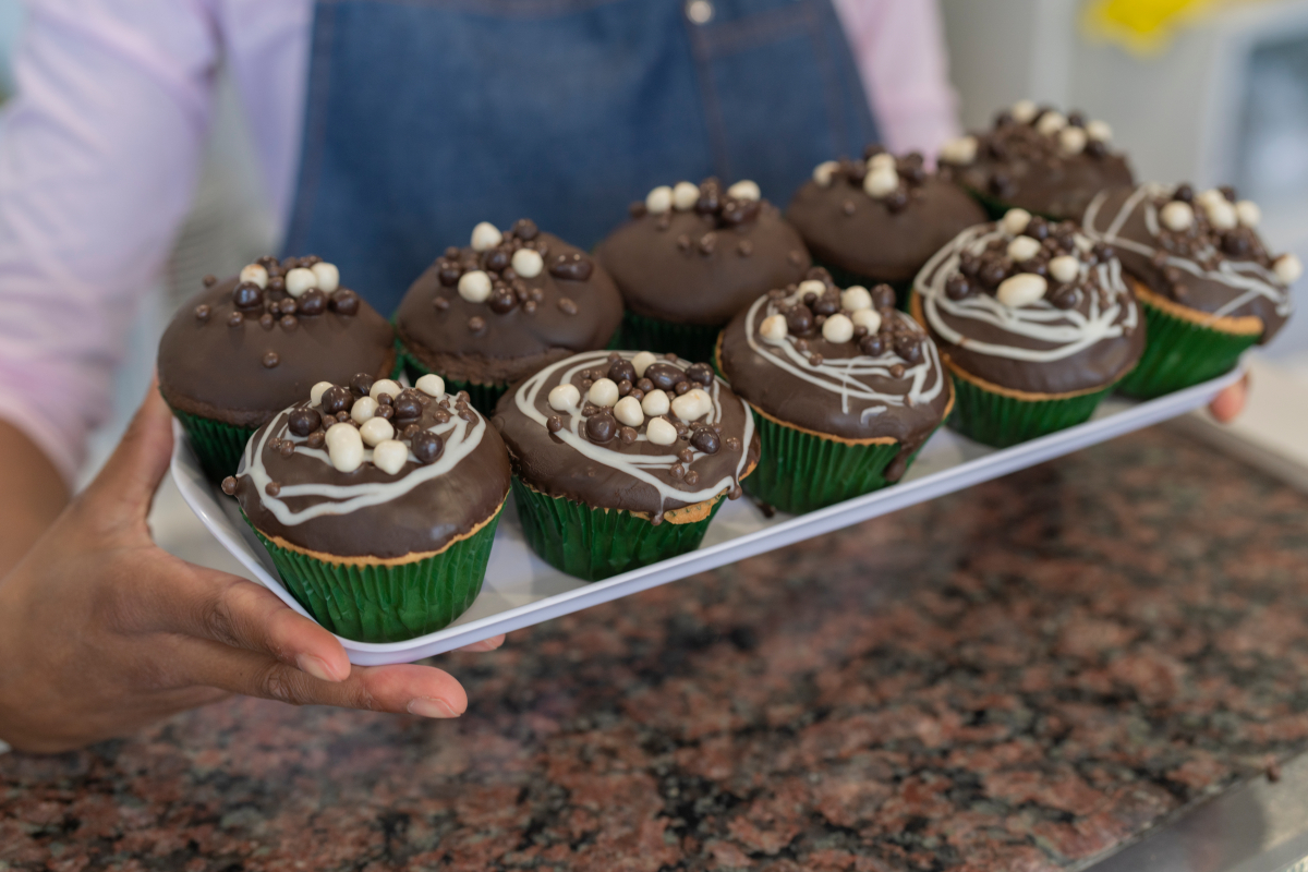 Halloween recipes: A woman holding a tray of black velvet cupcakes