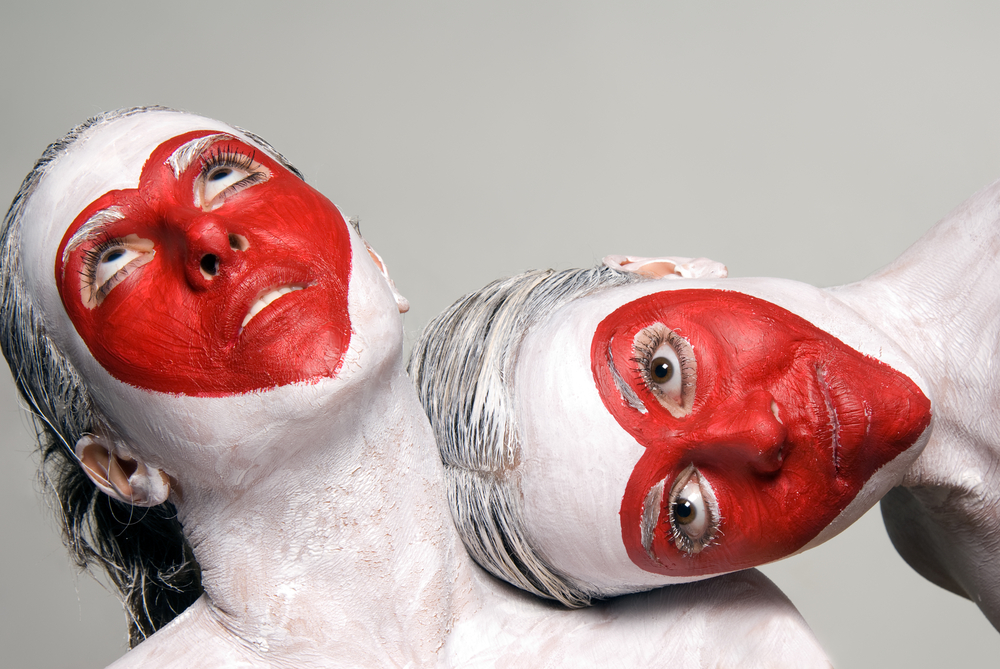 two girls with their faces painted white with red hearts