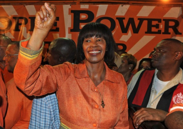 Portia Simpson Miller, leader of the People's National Party, pumps her fist to supporters during the victory rally of the parliamentary elections in Kingston, Jamaica, late Thursday, Dec. 29, 2011. Jamaica's opposition capitalized on discontent over the economy to return to power Thursday, defeating the center-right government of Prime Minister Andrew Holness, as voters gave the country's first female leader a second chance to govern the island. (AP Photo/Collin Reid)