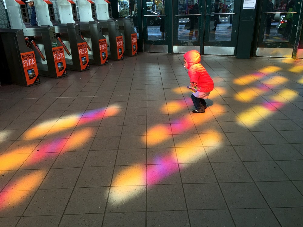 The subway station near my apartment has pink and yellow windows, and around 11am the sun is in the perfect spot to create these colors on the floor. As i was photographing them, the child in the photo started hopping around the colors. Their mother allowed me to use the photo, and the little one told me she though it was a cool photo.