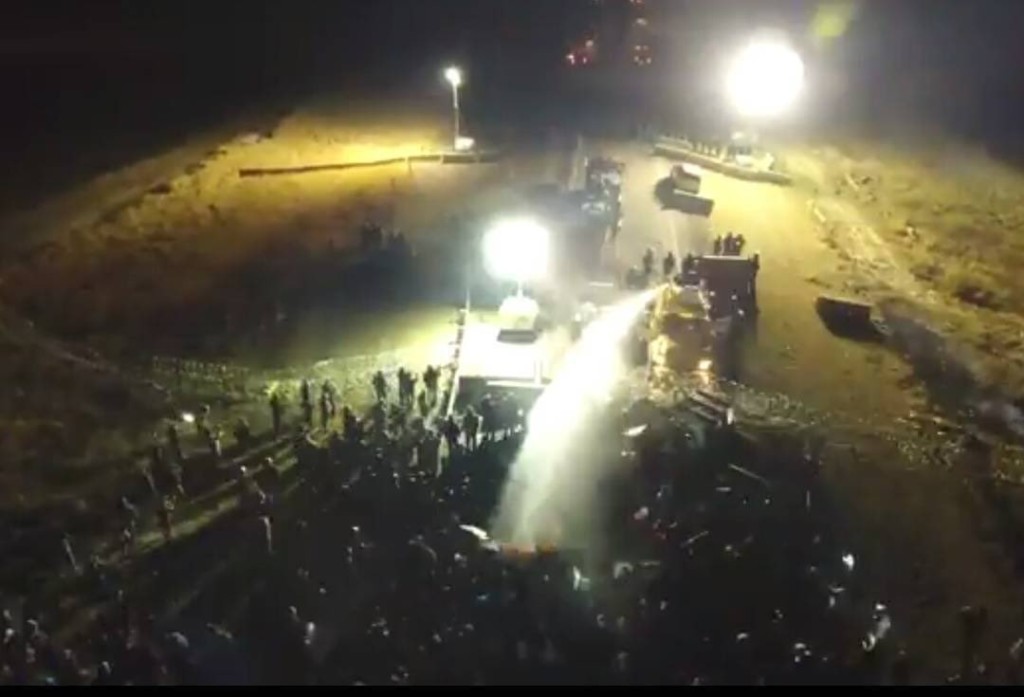 Drone footage of police using a water cannon on protestors while the temp hovered around 25° F.