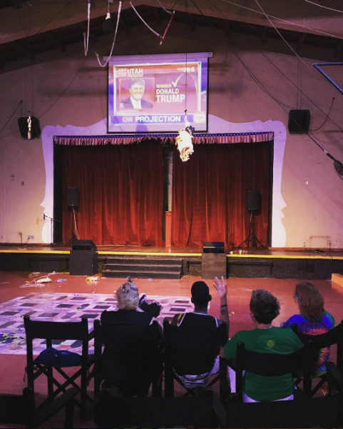 a destroyed donald trump piñata hangs in an auditorium full of depressed lesbians in ixtapa mexico