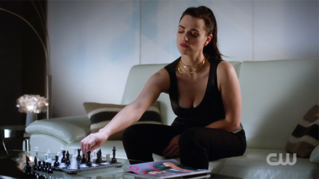 Lena reaches for a chess piece