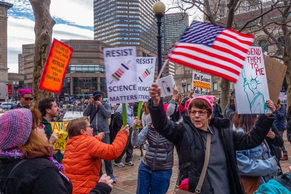 BOSTON, MA USA - FEBRUARY 19, 2017: Protesters hold up signs at the Stand Up for Science Rally in Copley Square Boston. Via Shutterstock.