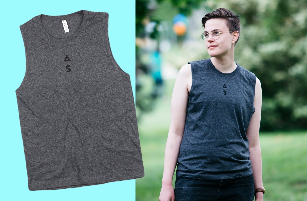Left: Grey Unisex Muscle Tank with Autostraddle logo screen printed top-center, just below neckline. / Al wearing Autostraddle tank.
