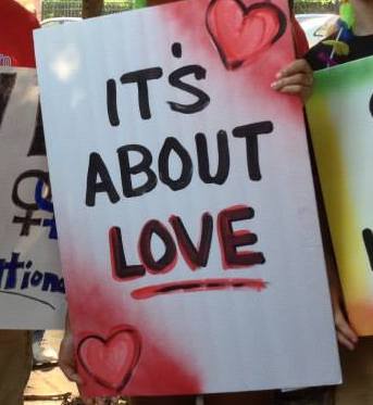 A spray-painted sign that says "It's about Love" from a marriage rally.