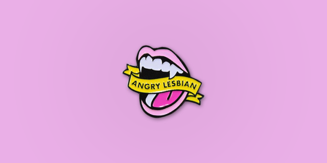 Angry Lesbian Enamel Pin / Description: Shouting Mouth with Vampire Teeth, Banner reads: "Angry Lesbian" / Metal: Black Enamel / Enamel Colors : Baby Pink, Lime Green, Magenta.