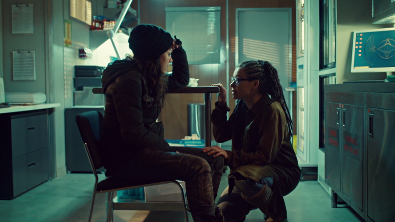 Sarah sits and Cosima crouches in front of her to talk