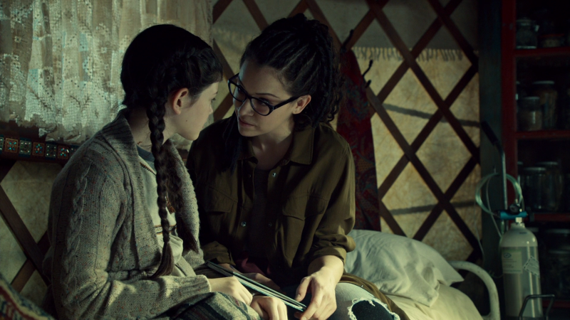 Cosima and Charlotte smile over a book together