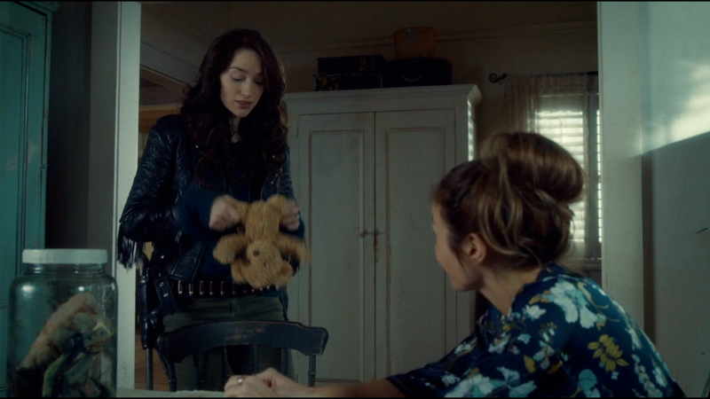 Wynonna holds a teddy bear at an awkward spread eagle type position