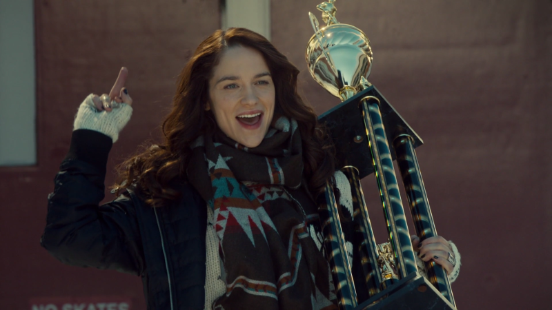 Wynonna does a victory walk out of the school with her trophy and her middle finger high in the air