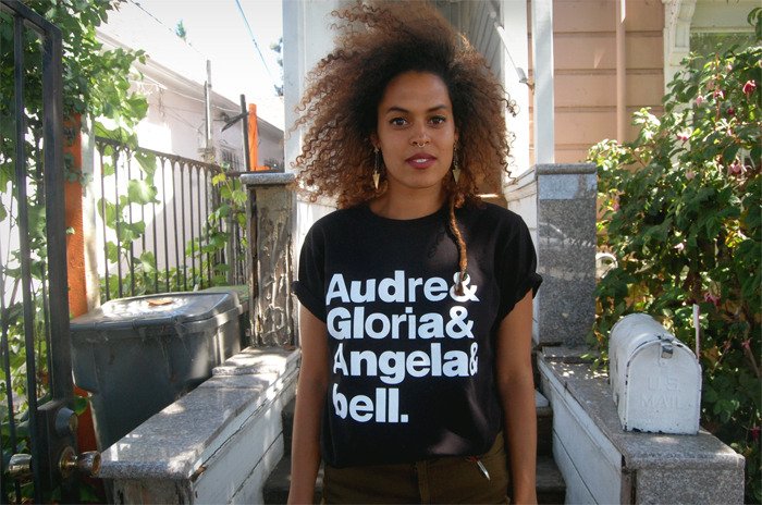 Black t-shirt with the stacked words in Helvetica-esque font: Audre & Gloria & Angela & bell.