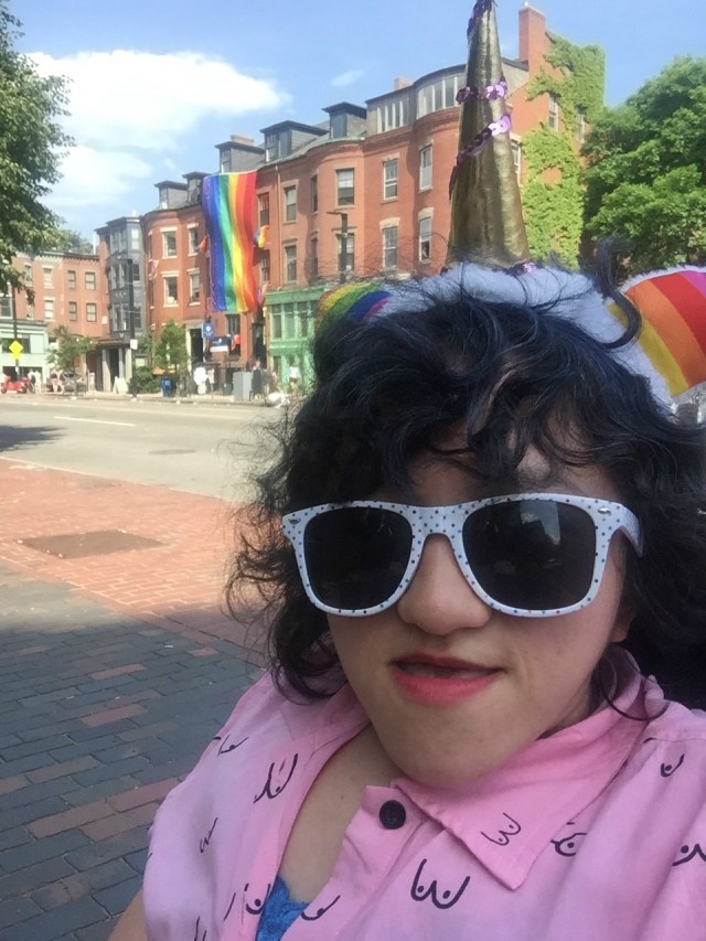 Sandy, a young Asian-American woman, takes a selfie at the 2017 Boston Pride Festival. She's wearing a rainbow flag headband and excellent polka dotted sunglasses.
