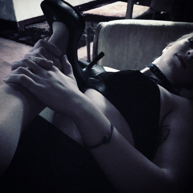 a woman's leg in a high-heeled shoe, lying across another woman's torso