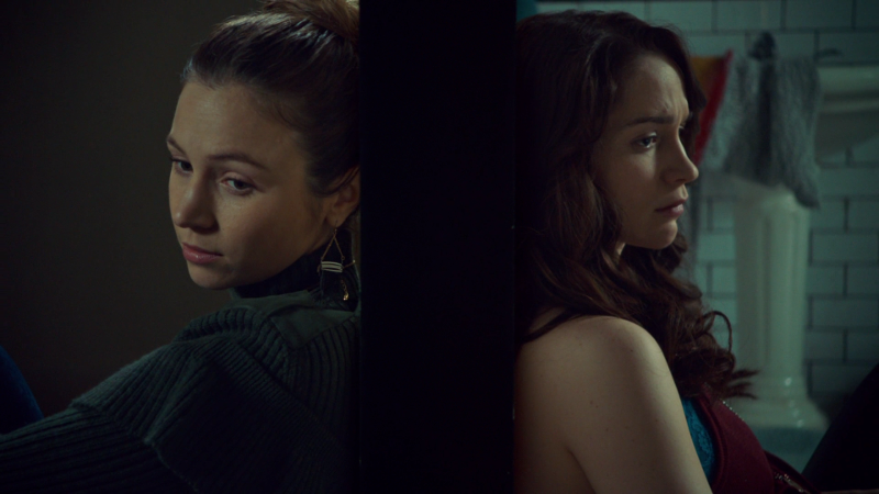 Waverly and Wynonna sit back to back on opposite sides of the bathroom door