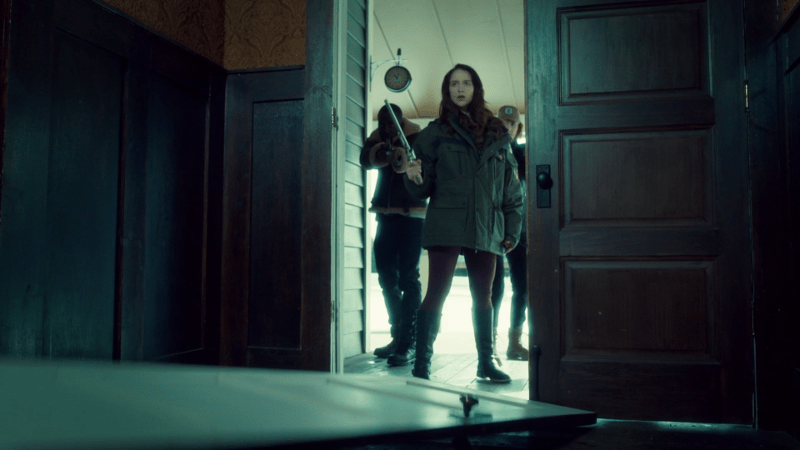 The door is on the floor and Wynonna is in the doorway, Haught and Dolls behind her