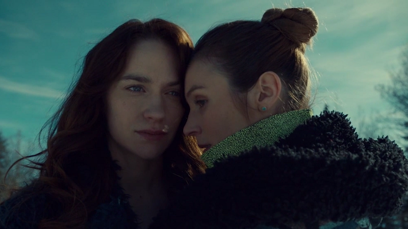 Wynonna and Waverly stand close to each other, holding each other a little