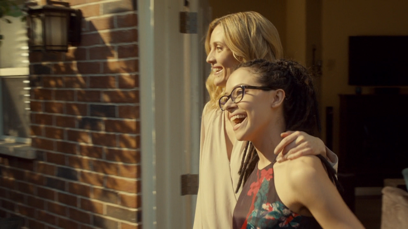 Cosima and Delphine enter the baby shower together, laughing