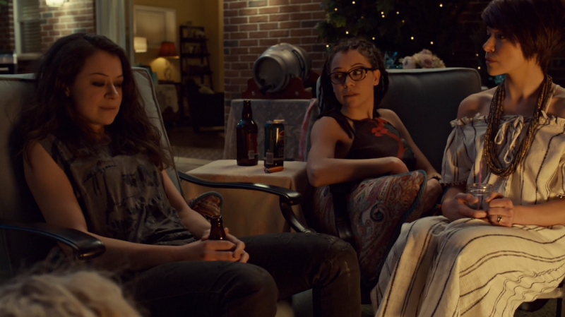 Sarah, Cosima and Alison sit together in the backyard (you can see the top of helena's head too)