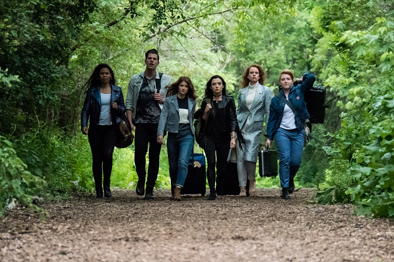 The cast of the Carmilla Move struts down a path in the forest