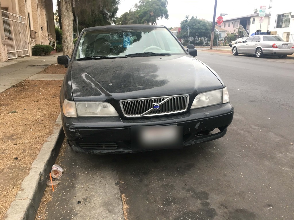 Photo of a black Volvo station wagon parked on a city street.