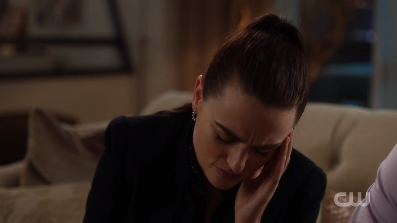 Lena holds her head and closes her eyes
