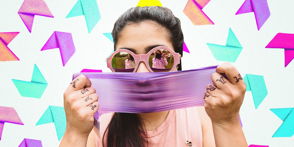 girl stretching a purple dental damn in front of her face, with a colorful background of folded up dental dams
