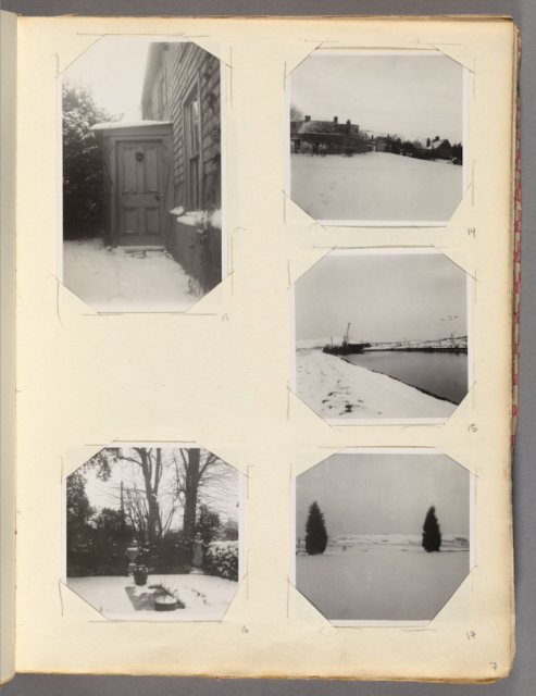 A page from an old photo album with five small black and white photos on it showing various winter landscapes (a door, a hillside with buildings, a marina, a field with two evergreen trees, a garden). 
