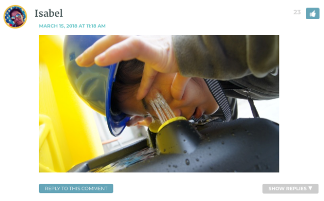 Photo of Isabel wearing a hard hat, washing her eyes out at a drinking fountain