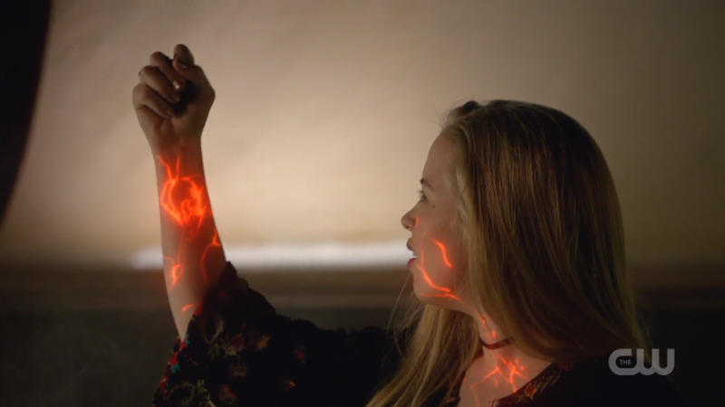 Olivia lights up with Reign's Worldkiller symbol on her arm and glowing lines in her face