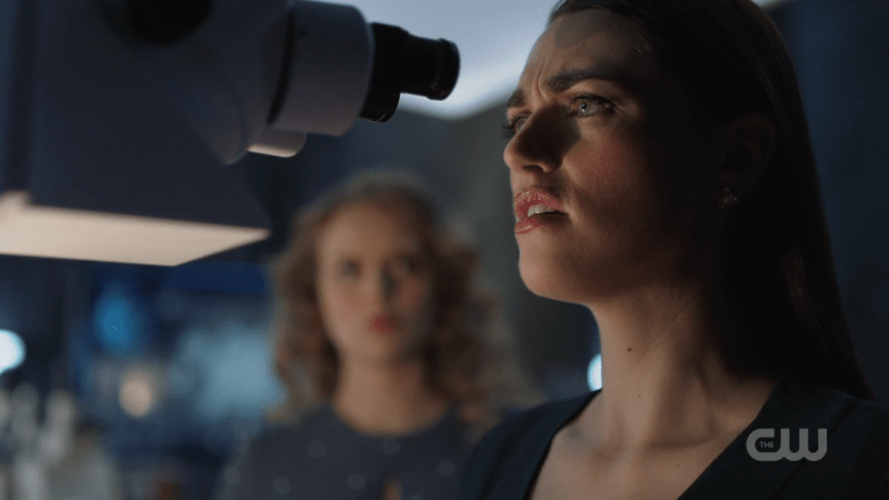 Lena looks through a microscope
