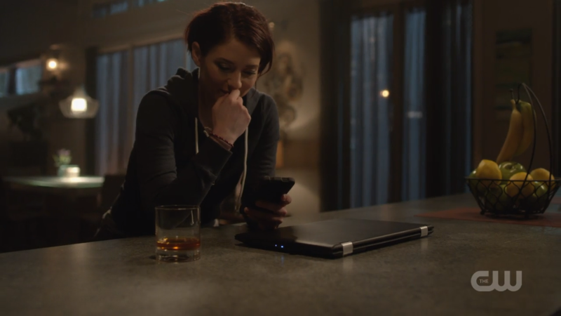 Alex puts down her whiskey and looks wistfully at her phone