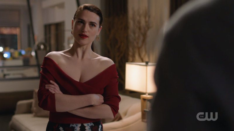 Lena and a low-cut, off-the-shoulder shirt crosses her arms 